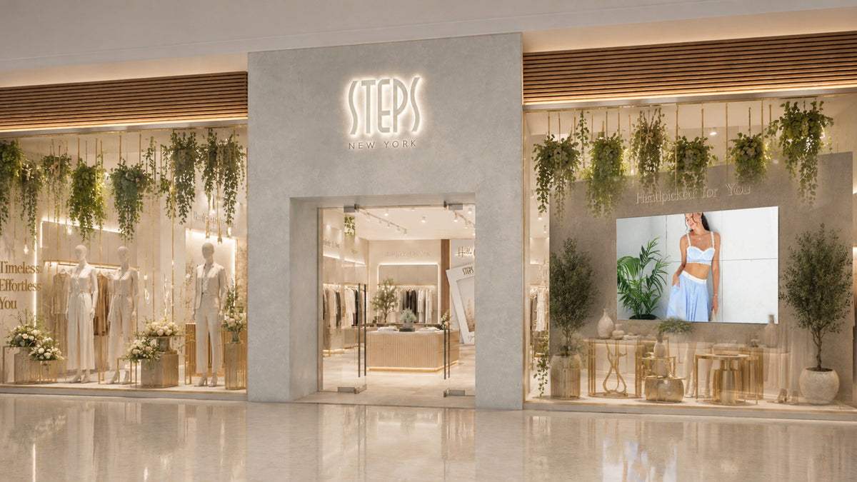 Steps New York storefront with window displays of neutral-toned outfits
